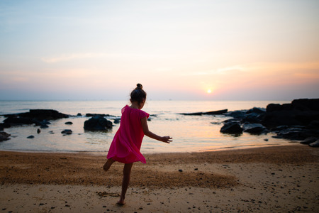 Girl playing on sunset beachの写真素材
