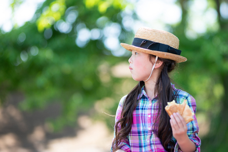 Girl eating sandwich at lunchtimeの写真素材