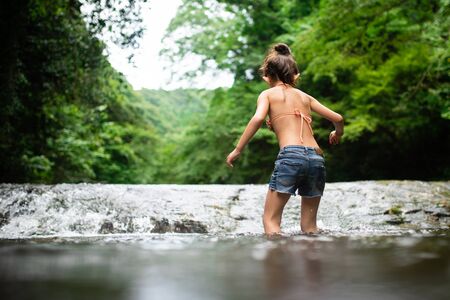 Girl playing in the riverの写真素材