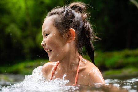 Girl playing in the riverの写真素材