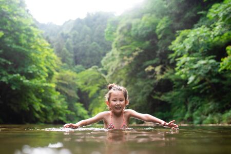 Girl playing in the riverの写真素材
