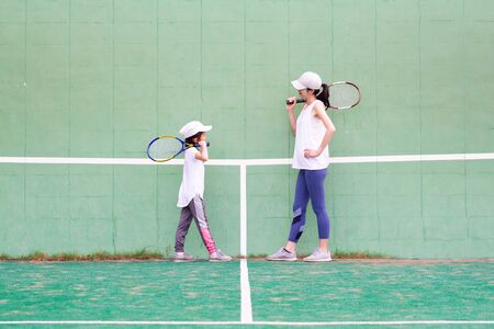 Mother and daughter practicing tennisの写真素材