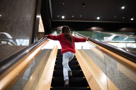 Girl riding the escalatorの写真素材