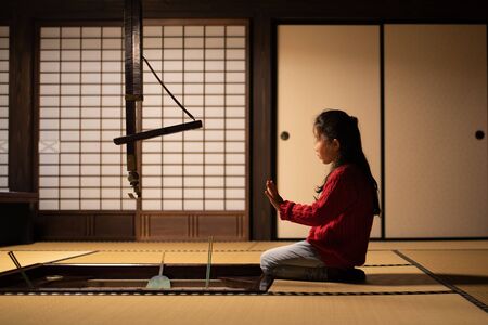 A girl sitting near the hearth in a Japanese style roomの写真素材