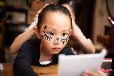 mother helps a girl to dress up for Halloween