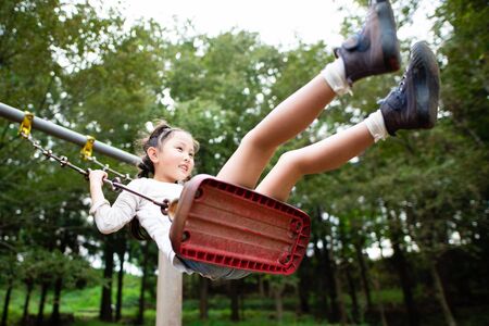 Cute girl playing on a swingの写真素材