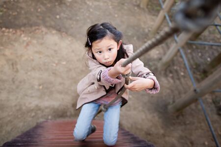 Girl climbing a rope in the parkの写真素材