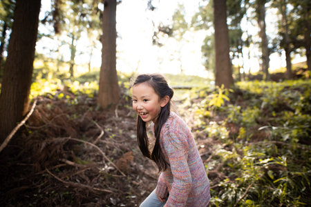 Smiling girl playing in autumn parkの写真素材