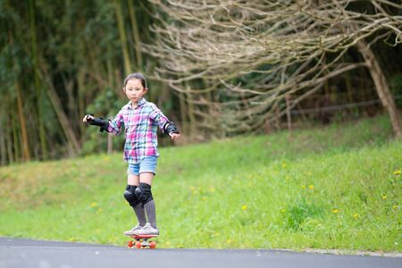 Girl playing with skateboard in parkの写真素材