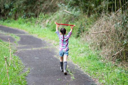 Girl holding a skateboard in her handの写真素材