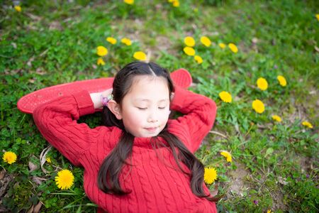 Girl taking a nap on the spring meadowの写真素材