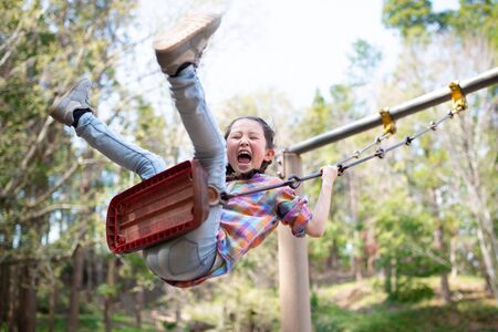 Girl playing on a swingの写真素材