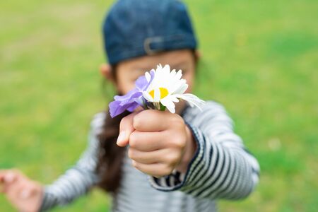 Child who hold out a flowerの写真素材