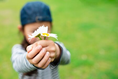 Child who hold out a flowerの写真素材