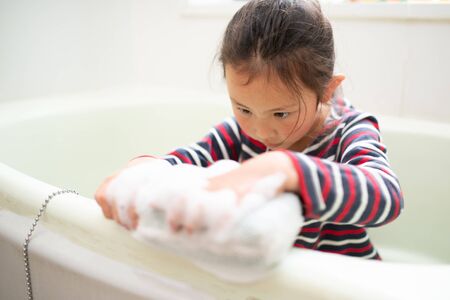 Girl washing the bath with a spongeの写真素材