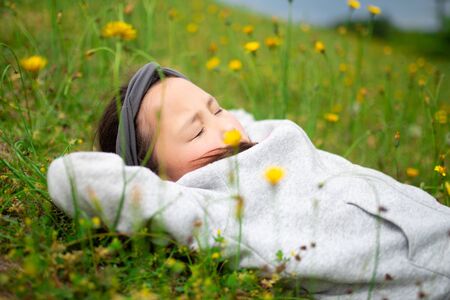 Girl taking a nap in the flower gardenの写真素材