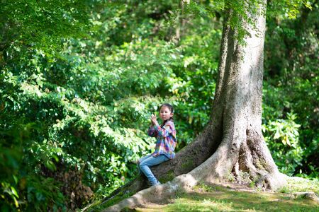 Girl sitting on a tree trunkの写真素材