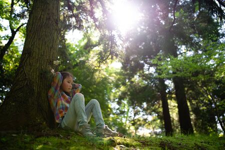 Girl sitting on a tree trunkの写真素材