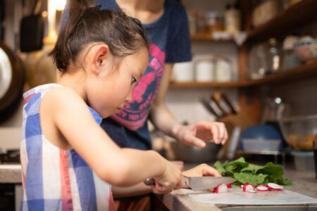 Girl teaching her mother to cookの写真素材