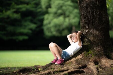 Girl relaxing in the shade of a treeの写真素材