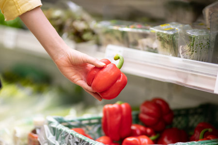 Female hand choosing paprika in supermarket