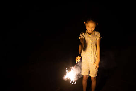 Girl playing with hand held fireworksの写真素材
