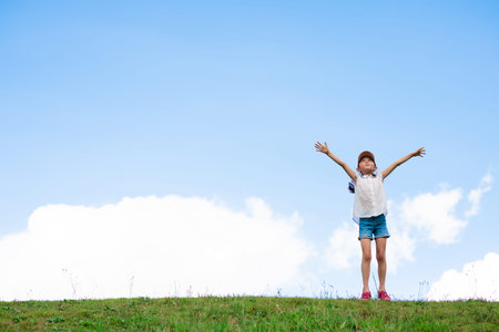 Child raising arms in the meadowの写真素材