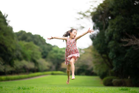 Girl playing barefoot on the lawnの写真素材
