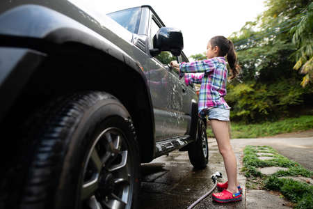 Cute girl washing a carの写真素材