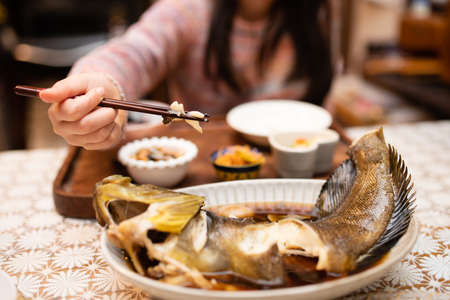 Child to eat grilled fish with chopsticksの写真素材