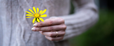 Woman presenting a yellow flower