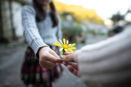 Mother and child handing yellow flowerの写真素材
