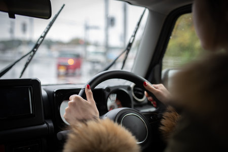 Woman driving a car on a rainy dayの写真素材