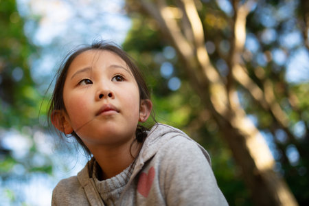A girl looking far in the woodsの写真素材