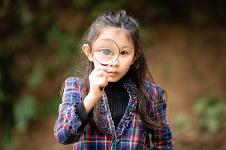 Girl playing with a magnifying glassの写真素材