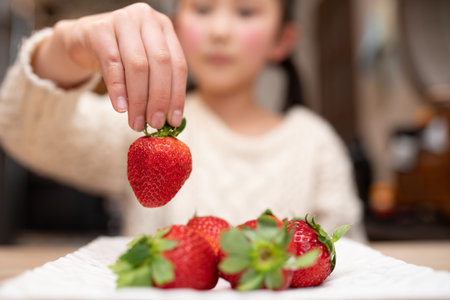 Child holds fresh strawberries in handの写真素材