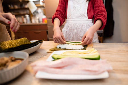 Mother and daughter making sushi rollsの写真素材