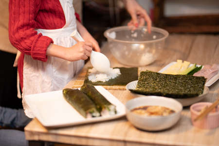 Mother and daughter making sushi rollsの写真素材