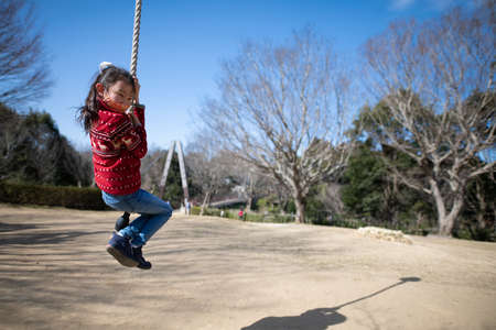Girl wearing a mask playing in a winter parkの写真素材