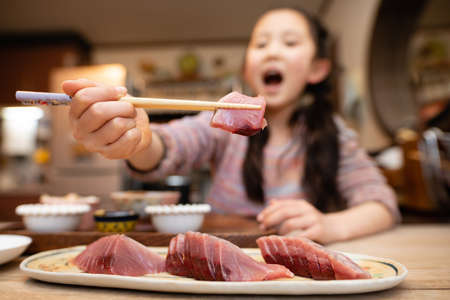 Girl eating sashimi of bonitoの写真素材