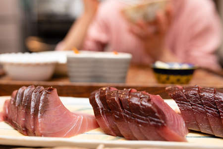 Girl eating sashimi of bonitoの写真素材