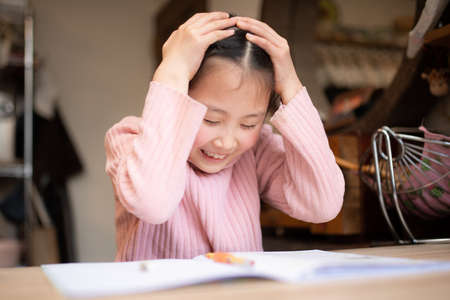 Girl holding her head while studyingの写真素材