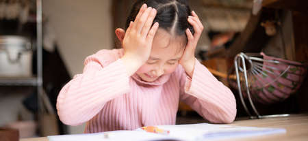 Girl holding her head while studyingの写真素材