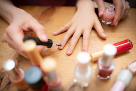 Mother's hand applying nail polish to her daughter's nailsの写真素材