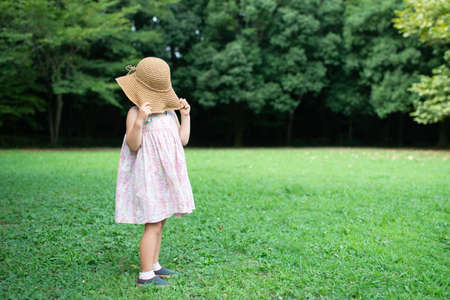 A girl blindfolded with a straw hatの写真素材