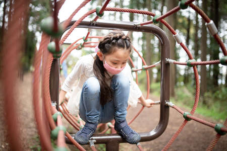 A child wearing a mask and playing in the parkの写真素材