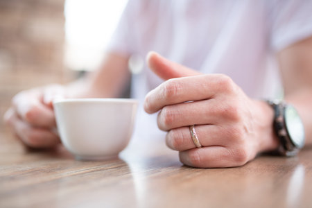 A man drinking coffee on the terrace of a restaurant
