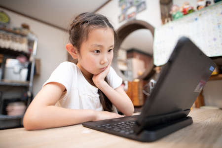 Girl using a laptop computer at homeの写真素材