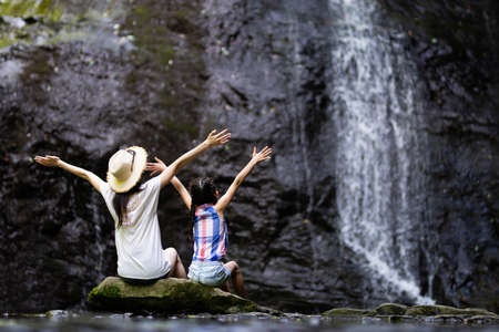 Mother and daughter playing in the mountain streamの写真素材