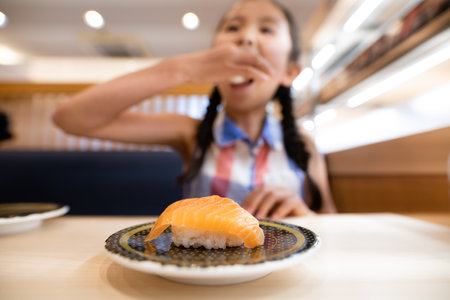 A child eating salmon sushiの写真素材